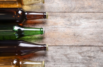 Photo of Bottles with different types of beer on wooden background