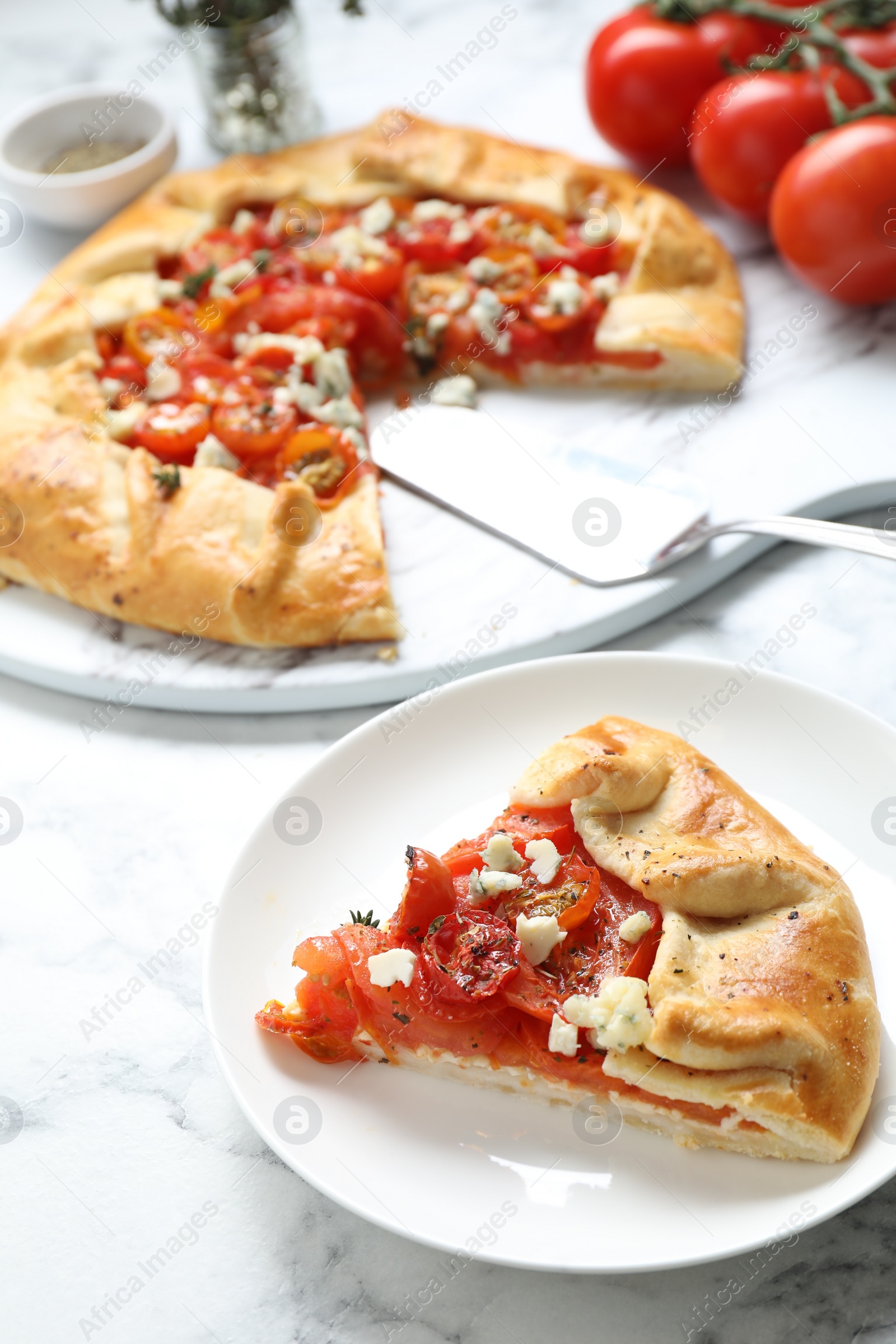 Photo of Tasty galette with tomato and cheese (Caprese galette) on white marble table, closeup