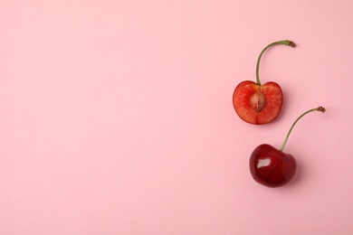 Photo of Cut and whole sweet cherries on pink background, top view. Space for text