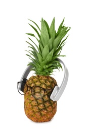 Photo of Fresh pineapple with headphones and glasses on white background