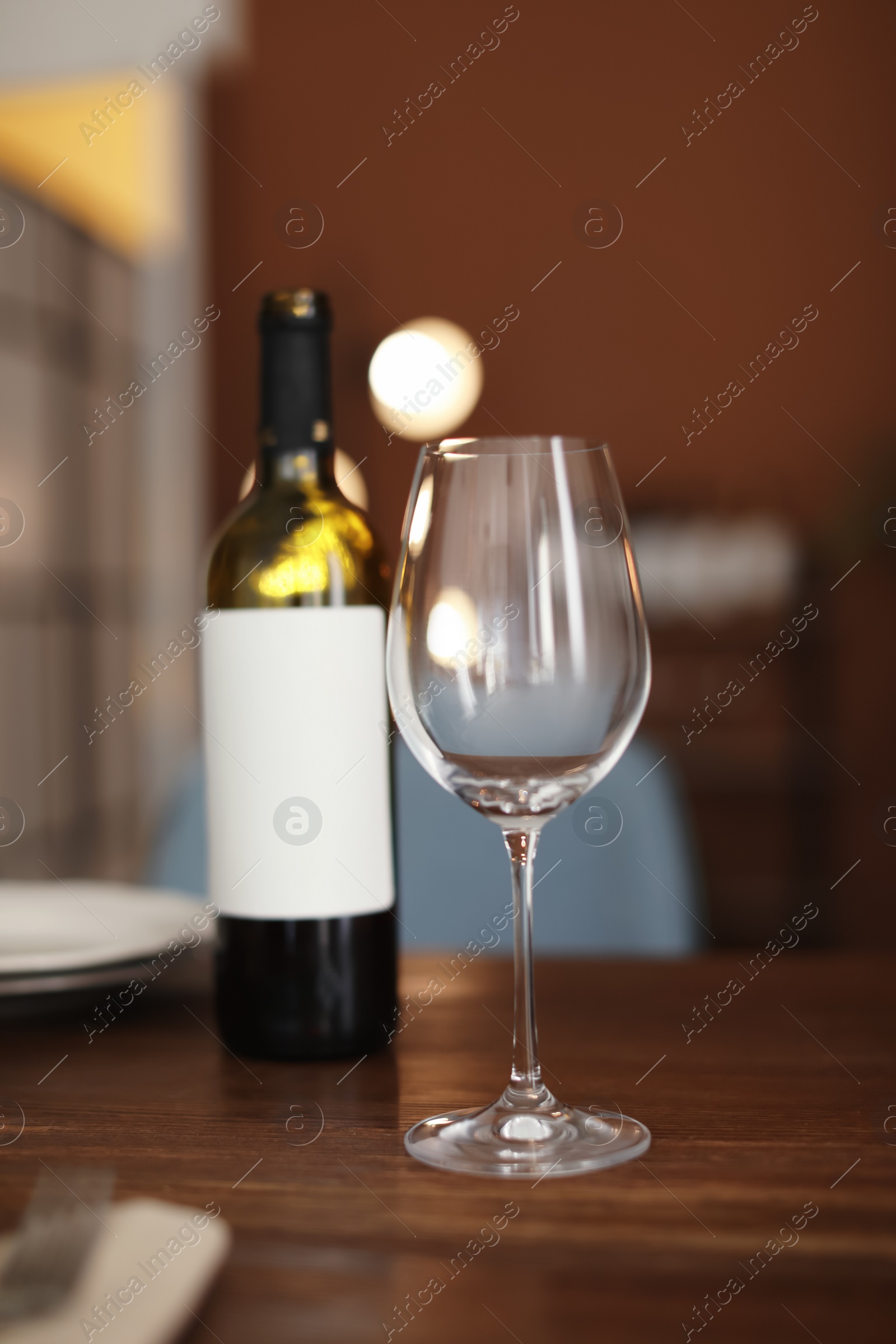 Photo of Glass and bottle of wine on table in restaurant