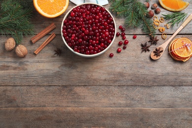 Flat lay composition with fresh ripe cranberries on wooden table. Space for text