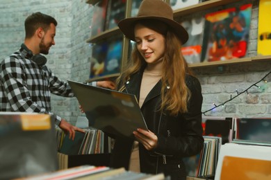 Image of Young woman with vinyl records in store