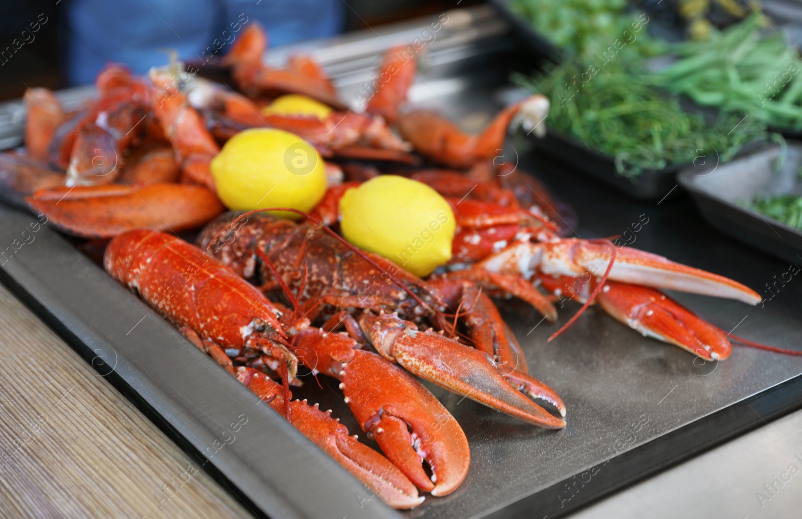 Photo of Delicious boiled crayfishes with lemons on table