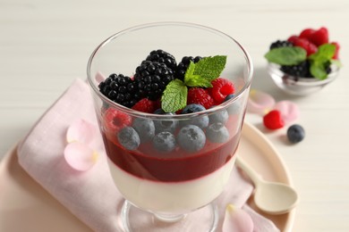 Photo of Delicious panna cotta with berries in glass dessert bowl, closeup