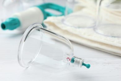 Photo of Cupping therapy. Plastic cup on white wooden table, closeup. Space for text