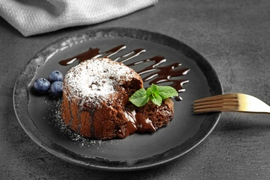 Plate of delicious fresh fondant with hot chocolate and blueberries on table. Lava cake recipe