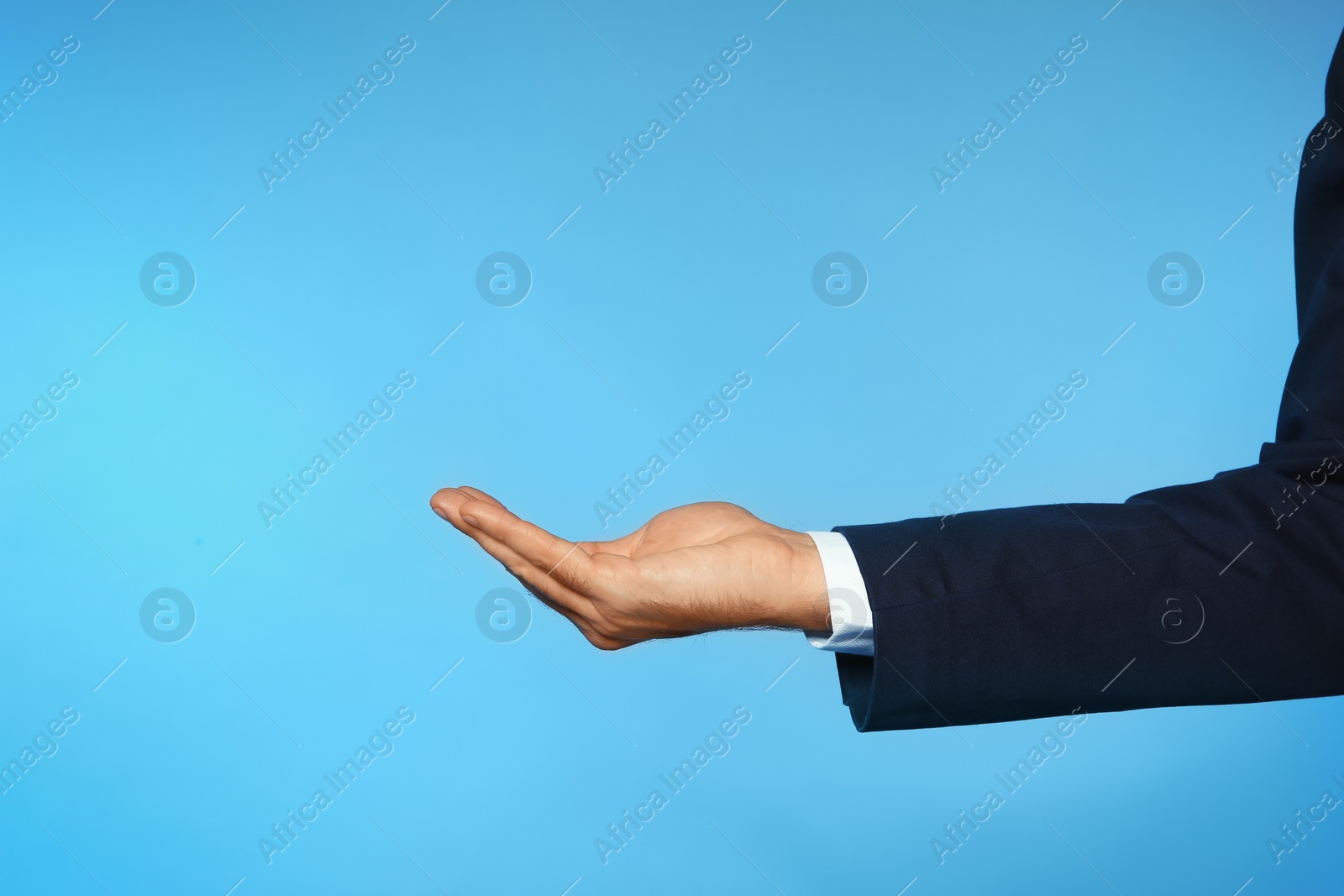 Photo of Businessman holding something on color background, closeup view of hand with space for text
