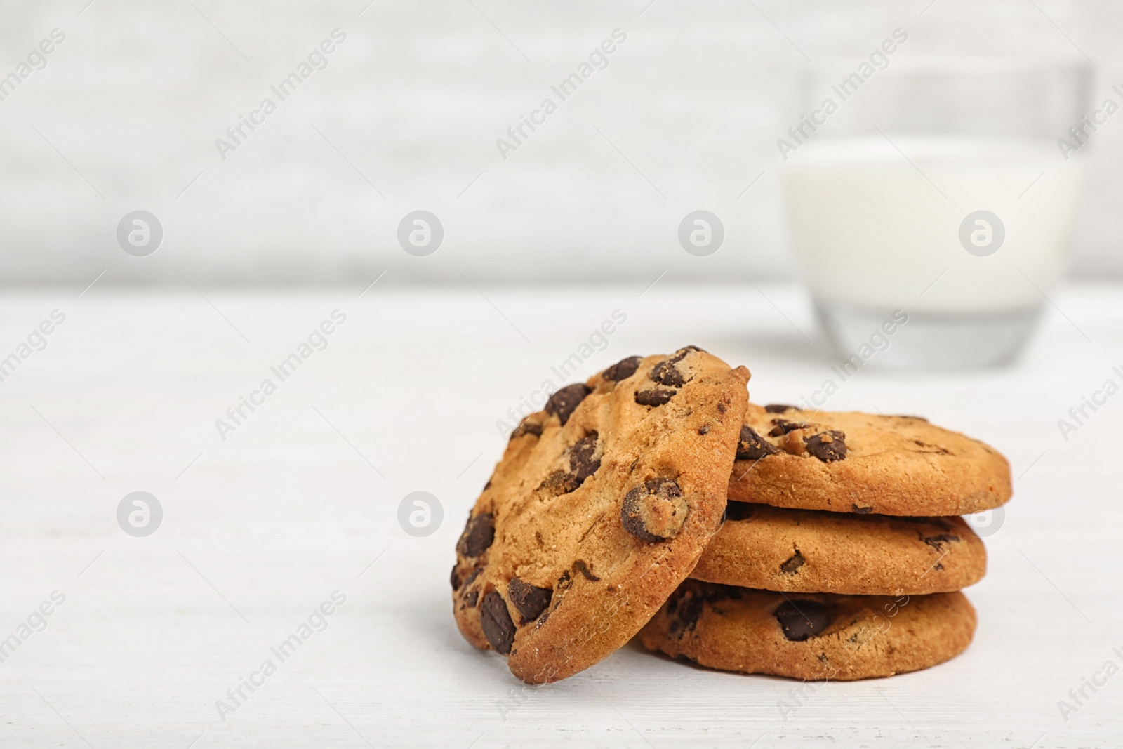 Photo of Tasty chocolate cookies on light table, space for text