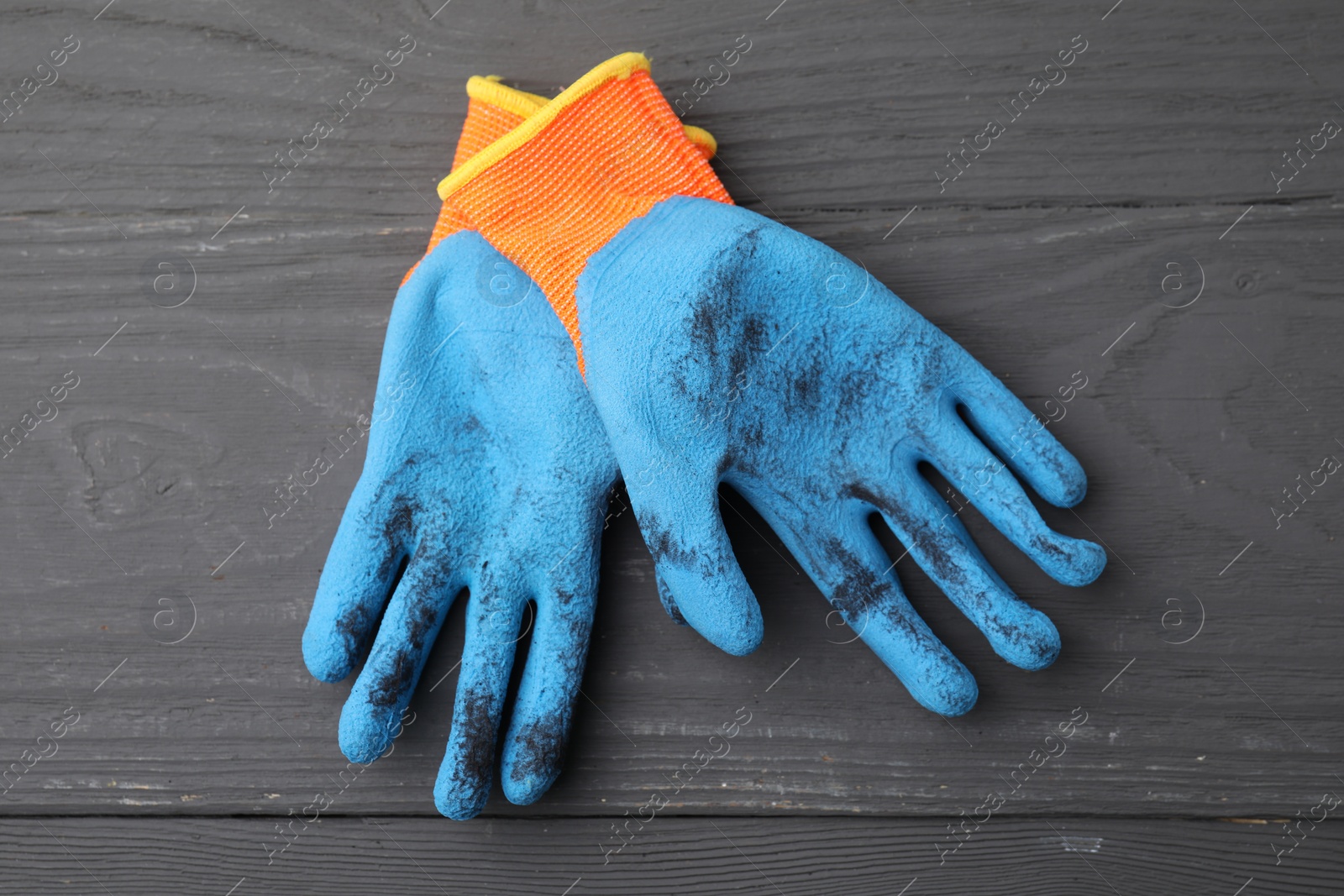 Photo of Pair of color gardening gloves on grey wooden table, top view