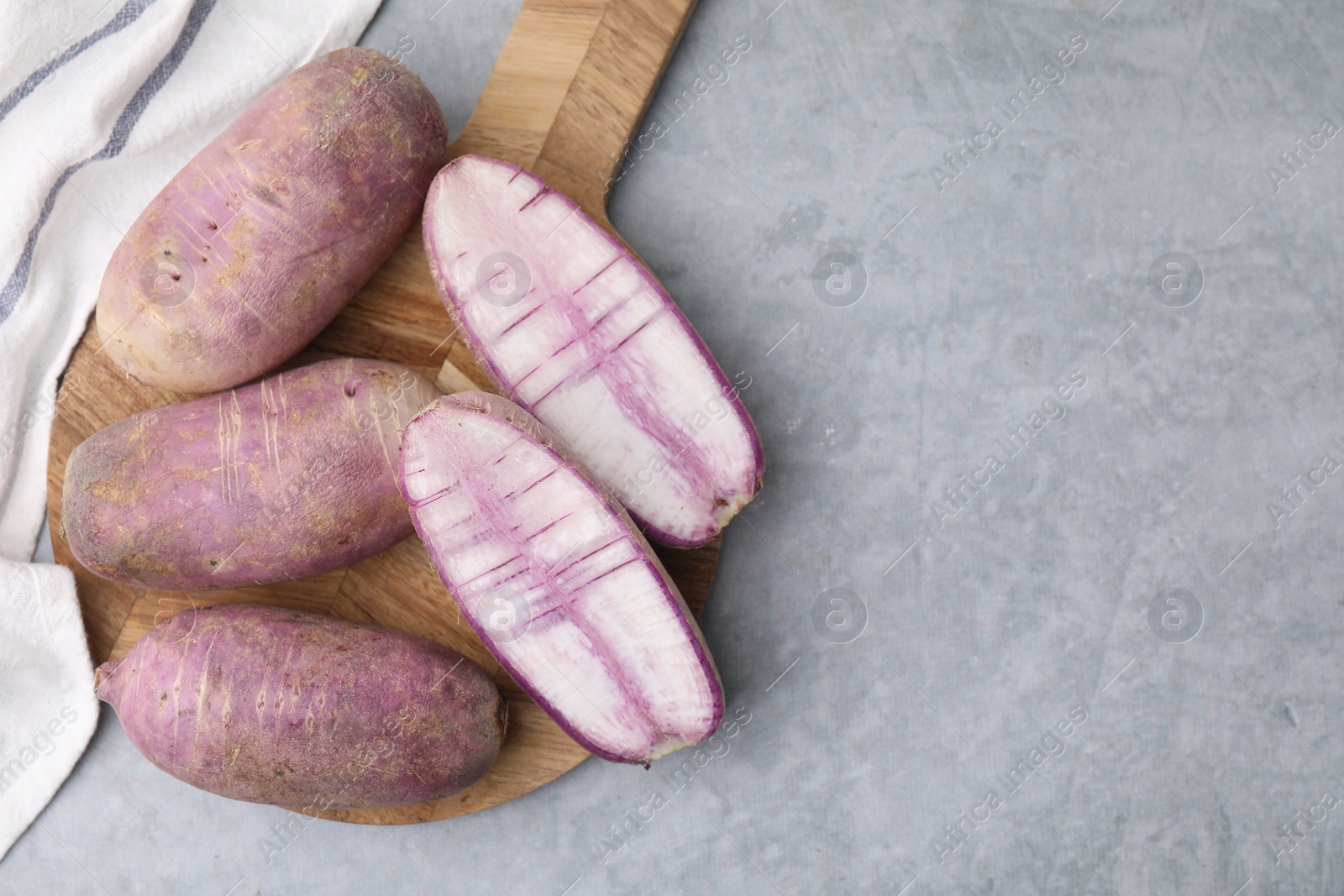 Photo of Purple daikon radishes on light grey table, top view. Space for text