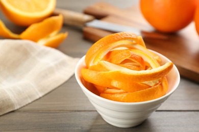 Photo of Fresh orange fruit peels on wooden table, closeup