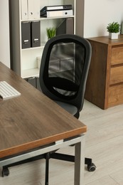 Stylish office chair at workplace in room. Interior design