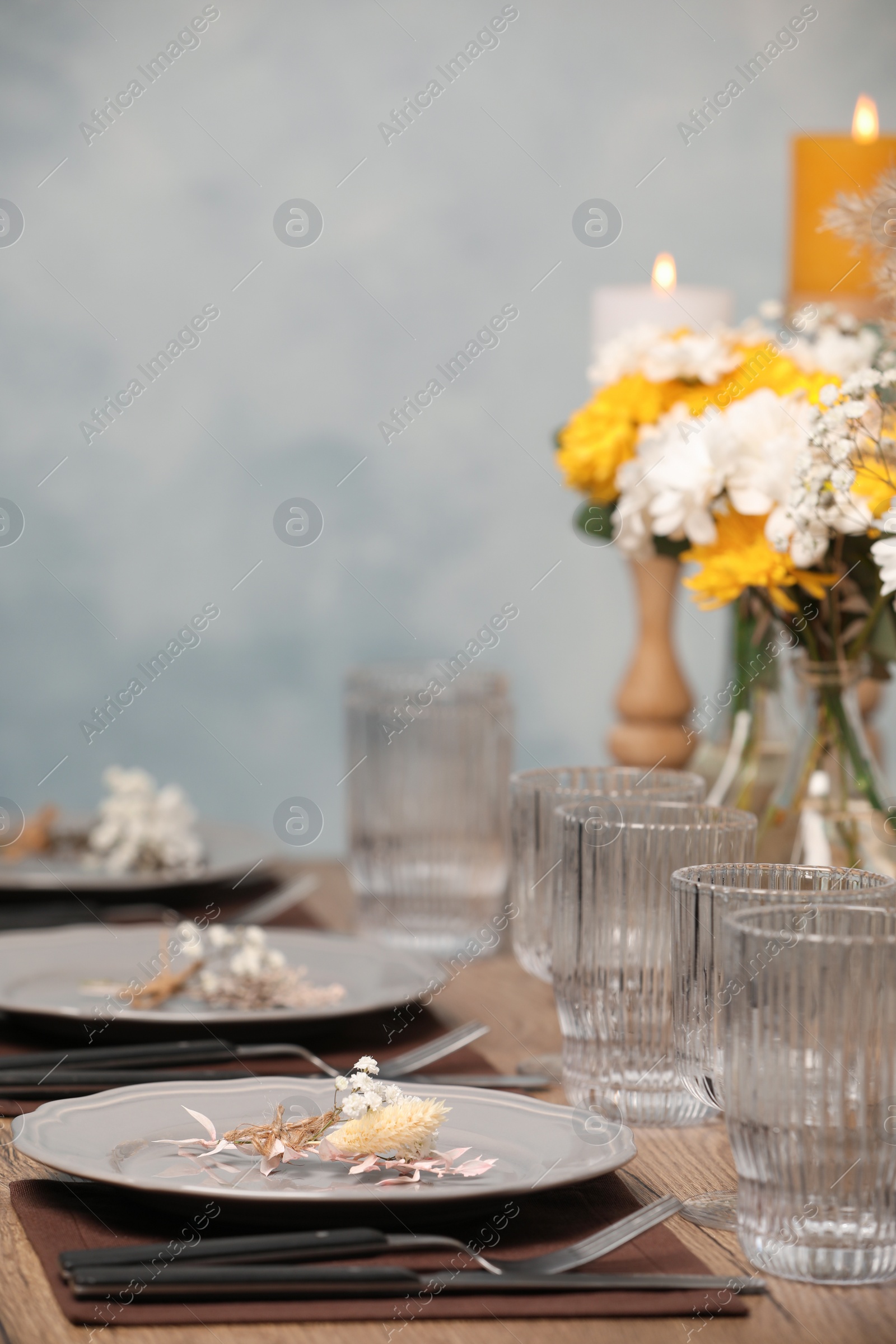 Photo of Elegant festive setting with floral decor on wooden table