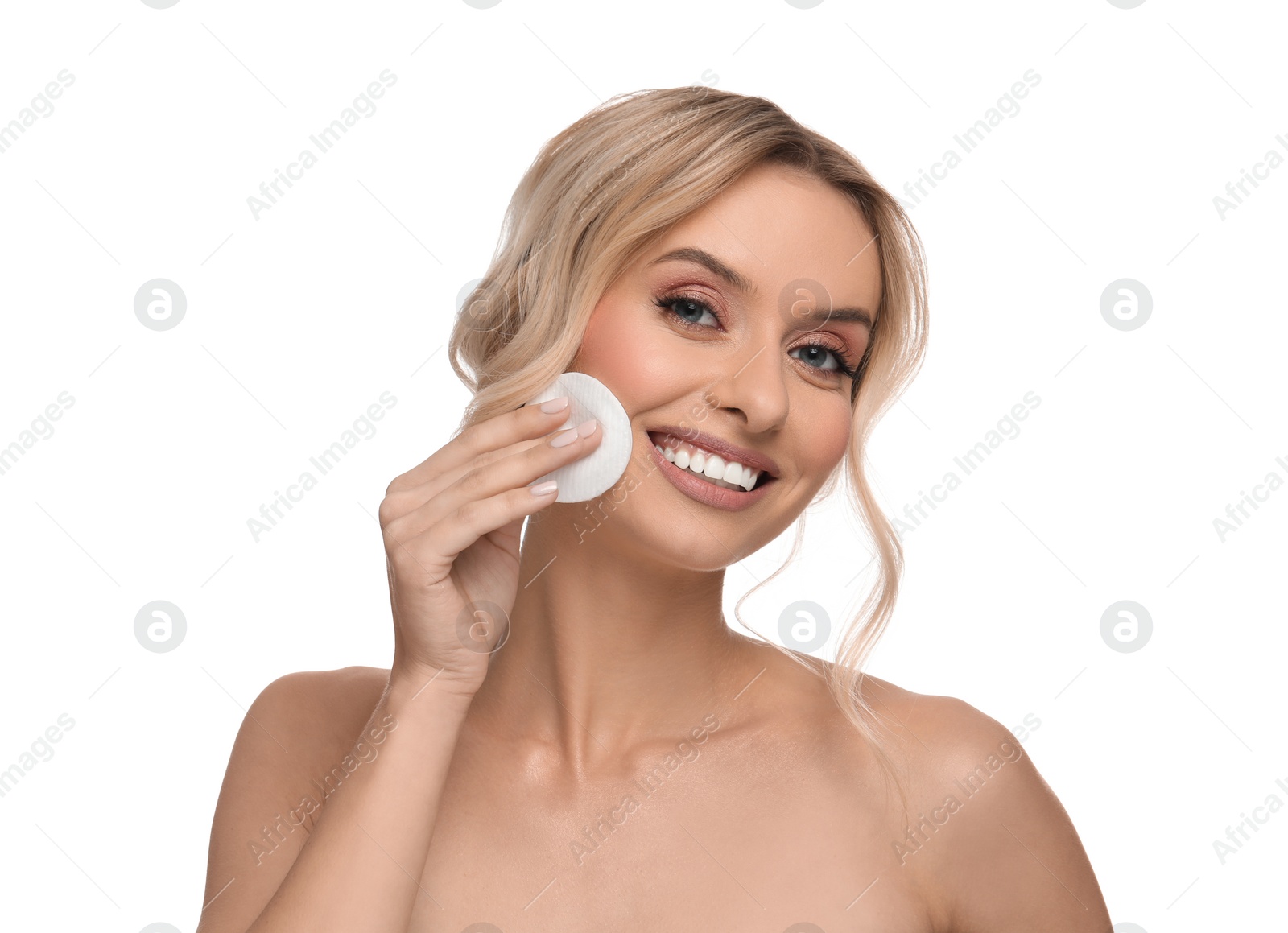 Photo of Smiling woman removing makeup with cotton pad on white background