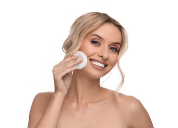 Photo of Smiling woman removing makeup with cotton pad on white background