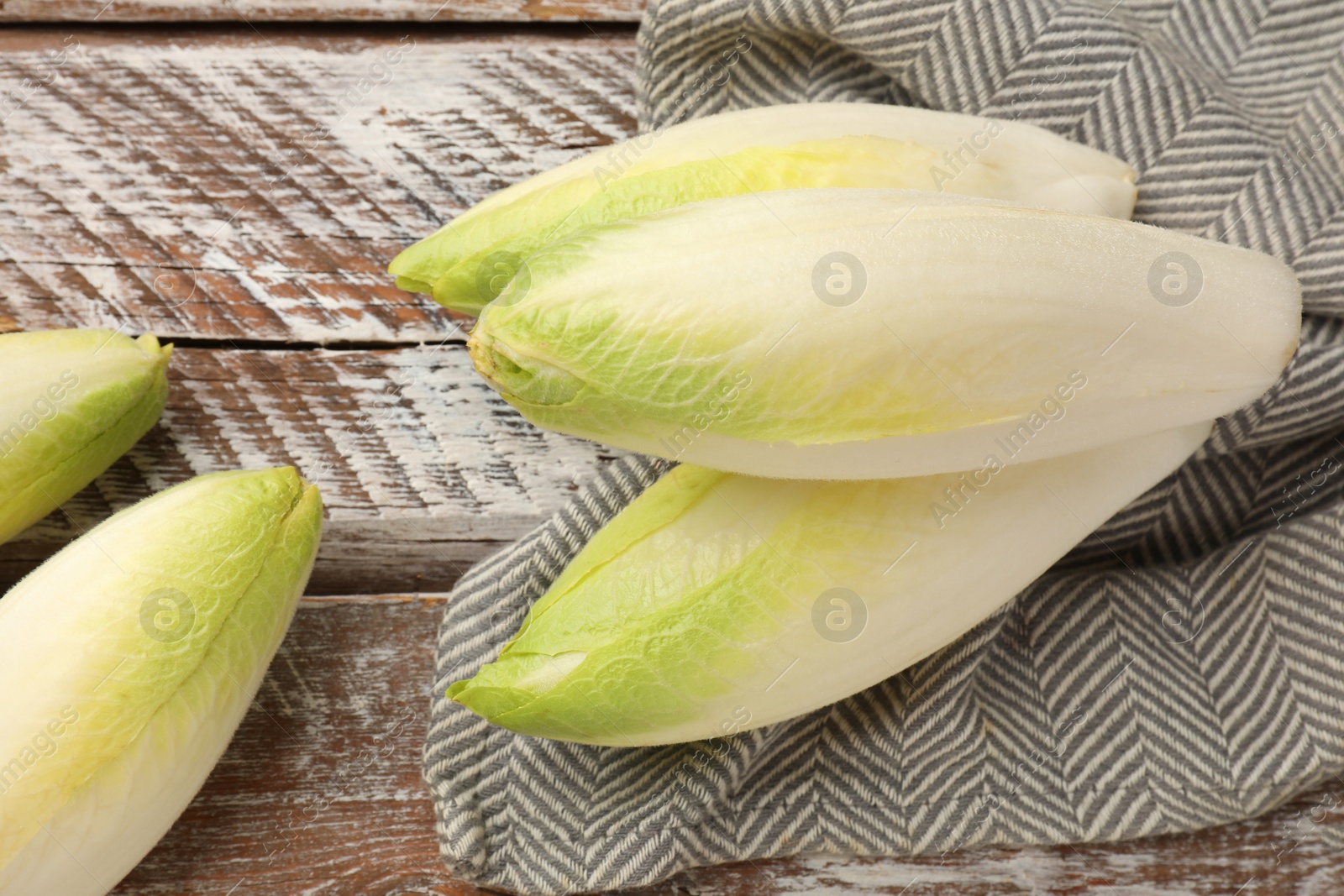 Photo of Fresh raw Belgian endives (chicory) on wooden table, top view