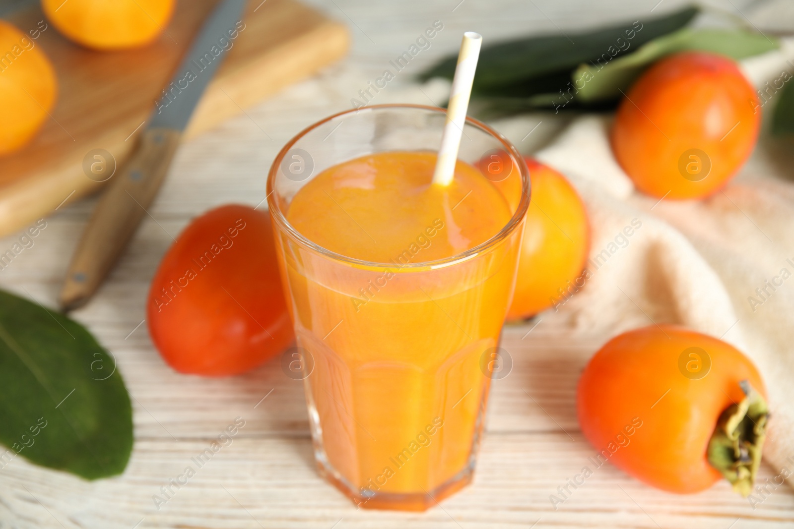 Photo of Tasty persimmon smoothie and fresh fruits on white wooden table, closeup