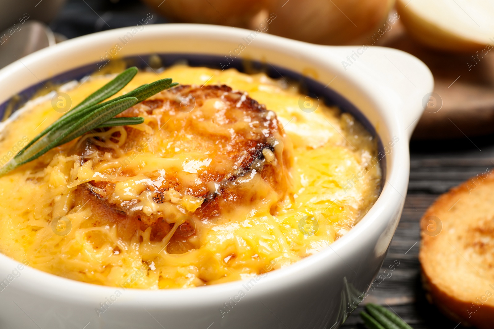 Photo of Tasty homemade french onion soup served in ceramic bowl, closeup