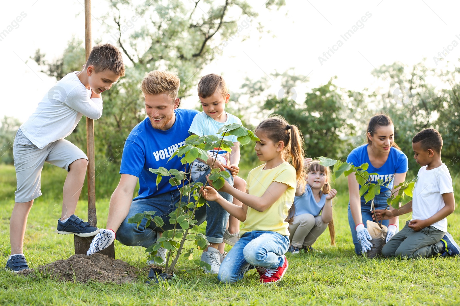 Photo of Kids planting trees with volunteers in park