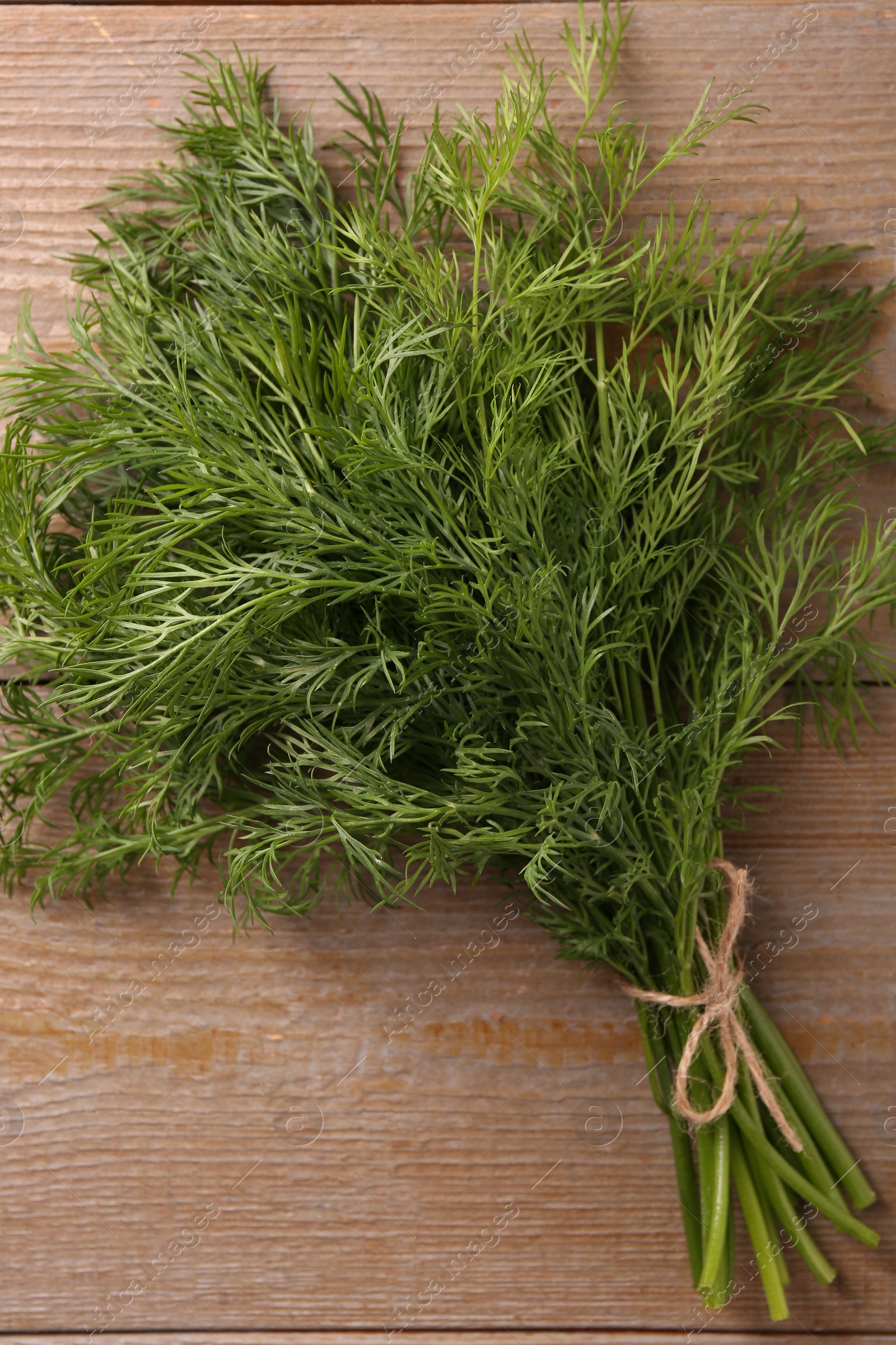 Photo of Bunch of fresh dill on wooden table, top view