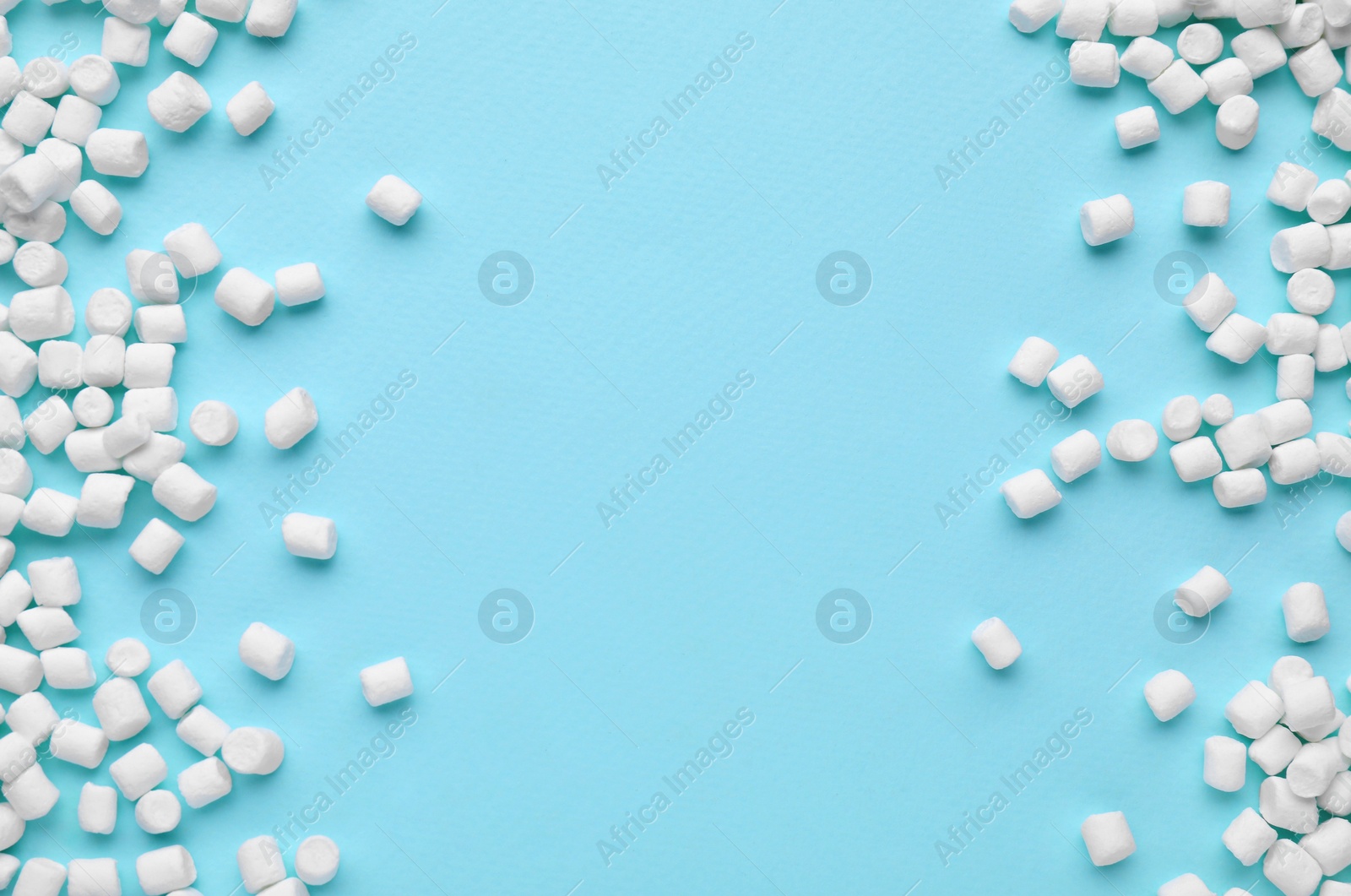 Photo of Delicious marshmallows on light blue background, flat lay. Space for text