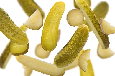 Image of Tasty pickled cucumbers falling on white background