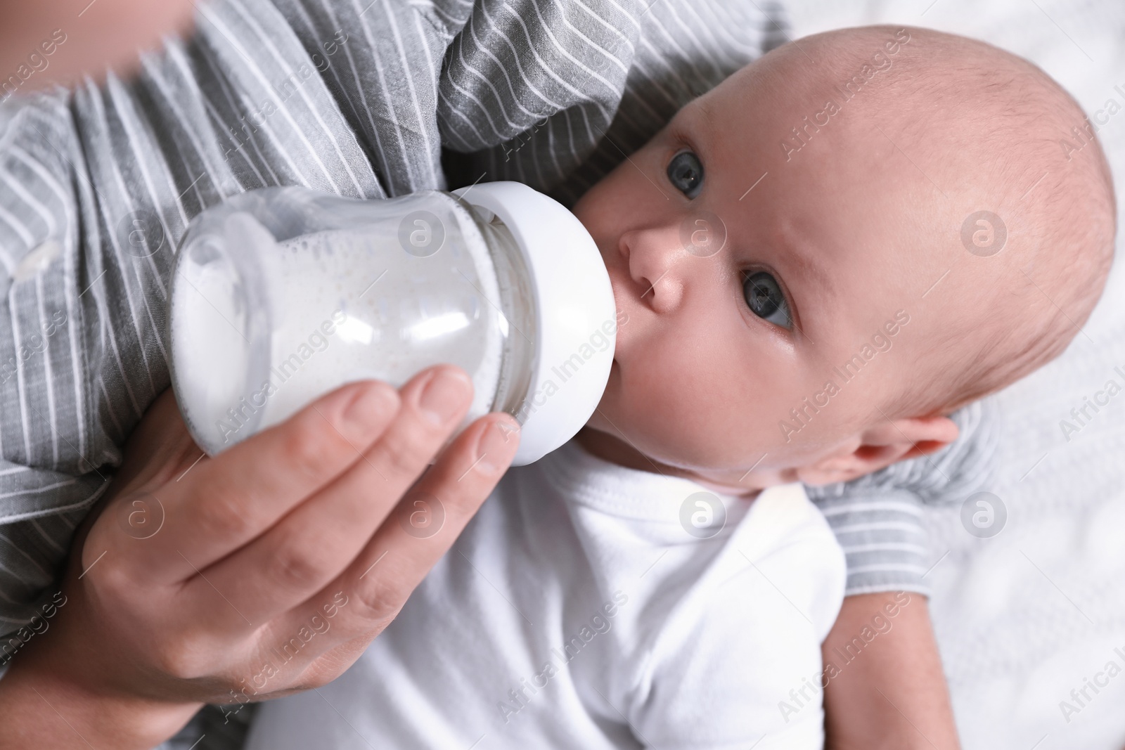 Photo of Mother feeding her little baby from bottle, closeup