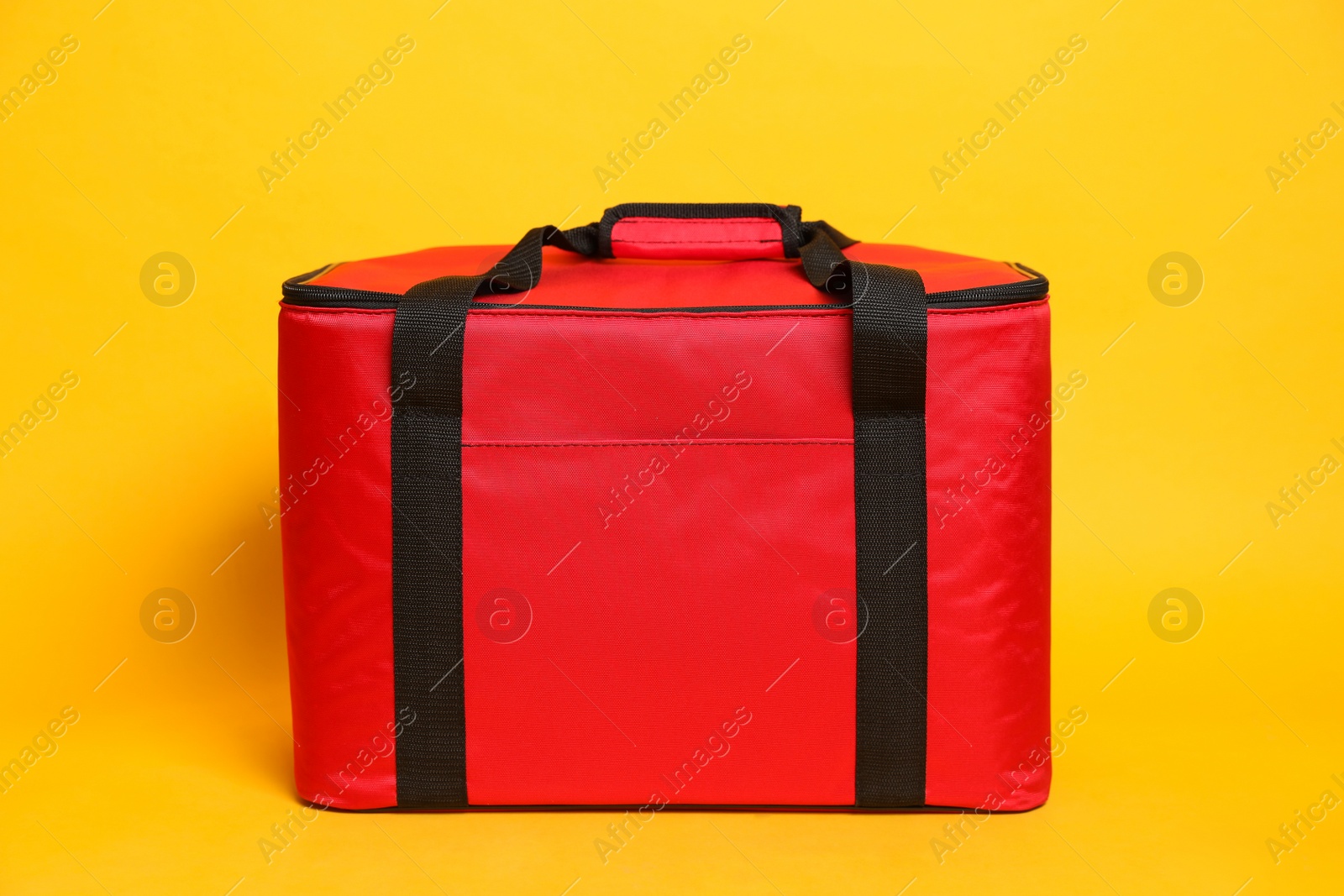 Photo of Modern red thermo bag on yellow background