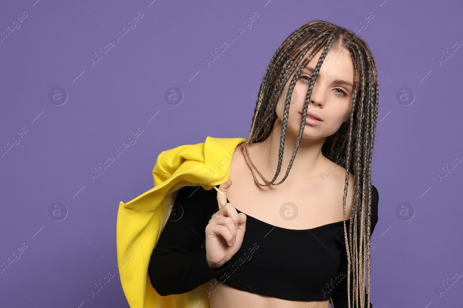 Photo of Beautiful woman with long african braids on purple background, space for text