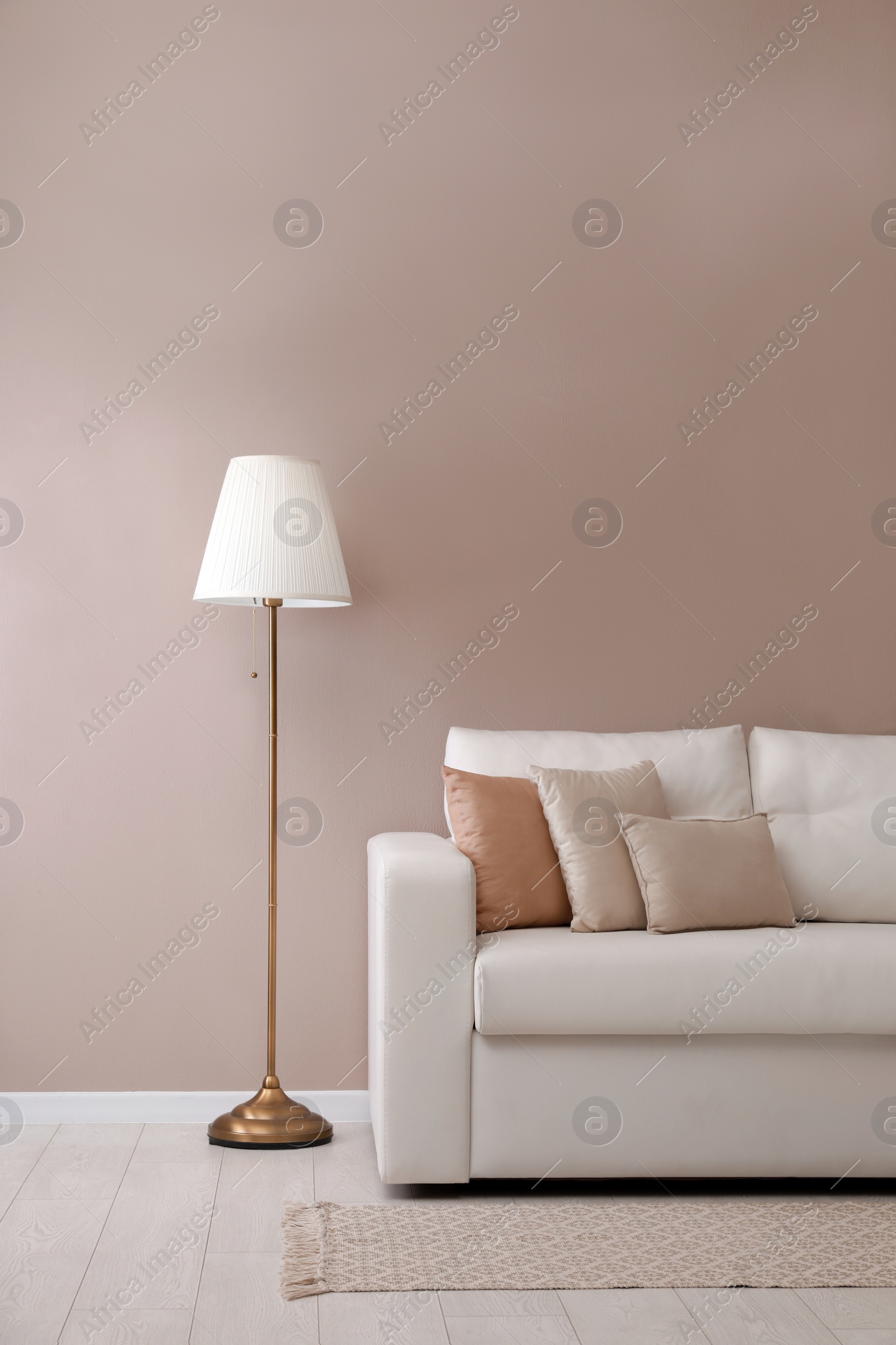 Photo of Stylish room living interior with comfortable sofa and lamp near beige wall