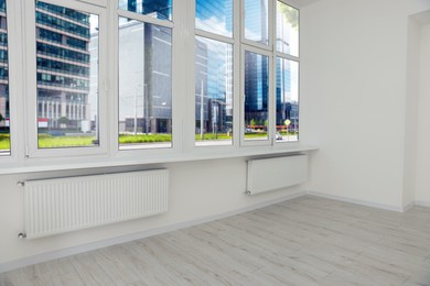 Photo of Empty office room with clean windows and radiators. Interior design