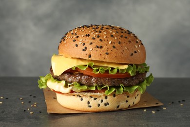 Photo of Burger with delicious patty on gray table