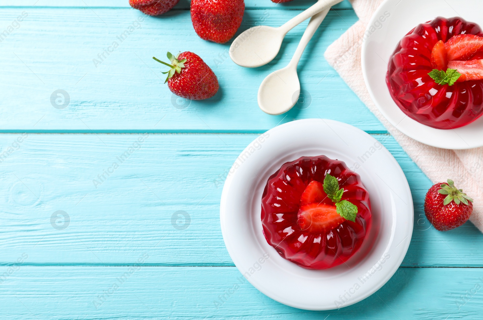 Photo of Delicious red jelly with strawberries and mint on light blue wooden table, flat lay. Space for text