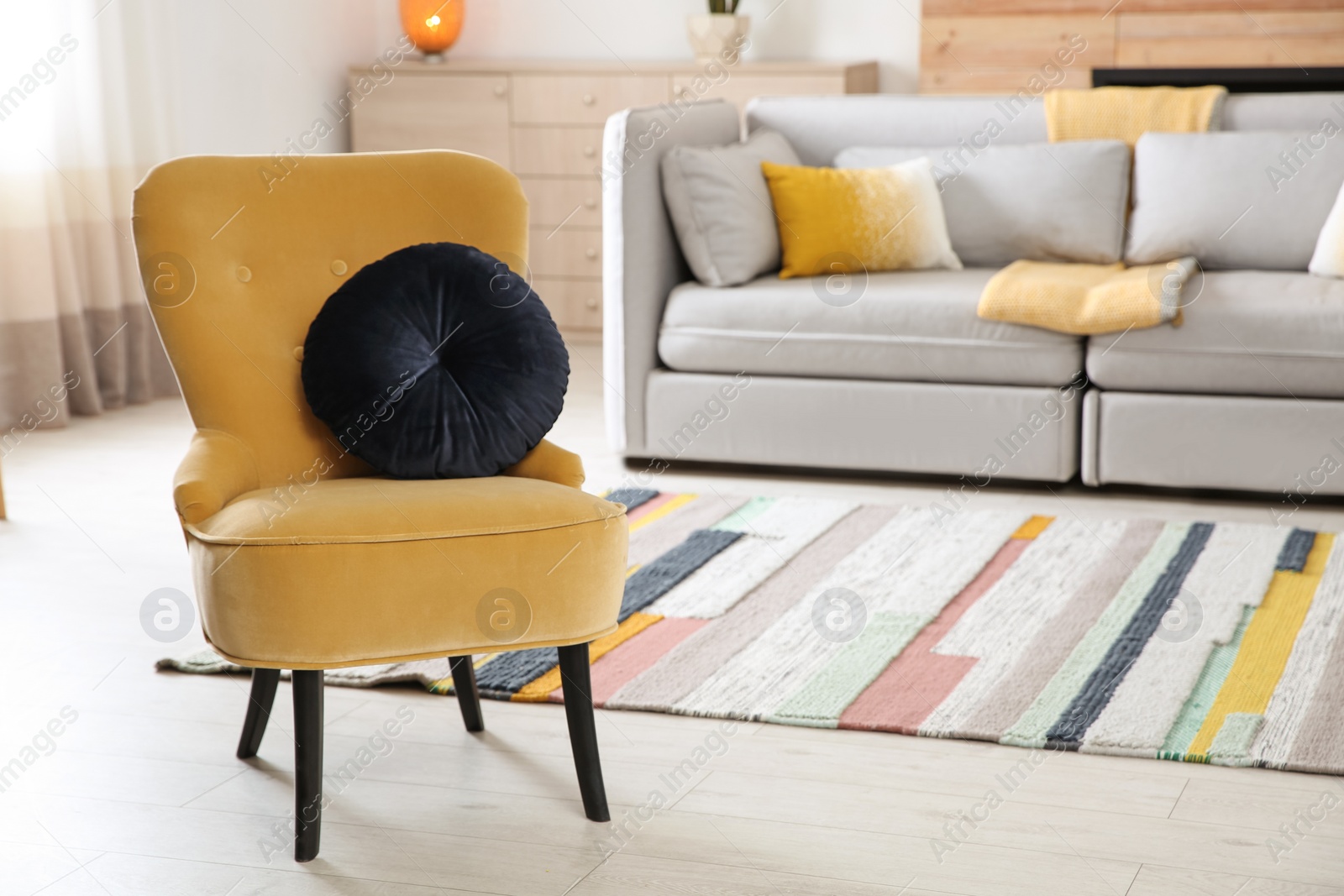 Comfortable armchair with soft cushion in modern living room interior. Space for text Photo of Comfortable armchair with soft cushion in modern living room interior. Space for text