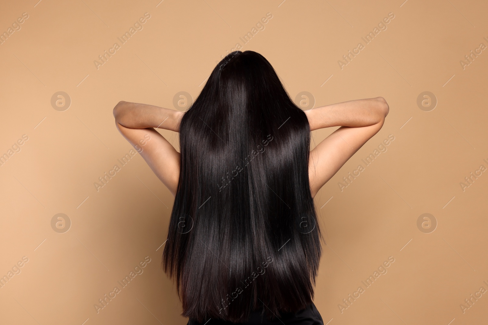 Photo of Woman with strong healthy hair on beige background, back view