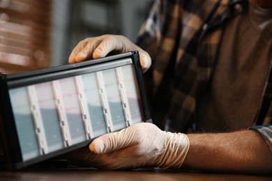 Professional repairman fixing modern printer indoors, closeup