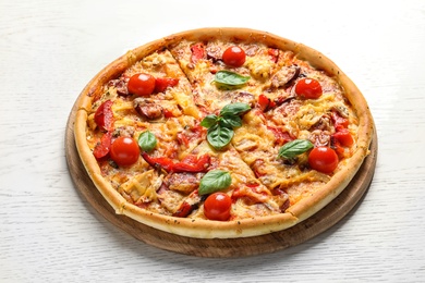Delicious pizza with tomatoes and sausages on table