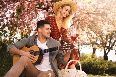 Photo of Lovely couple having picnic in park on sunny spring day
