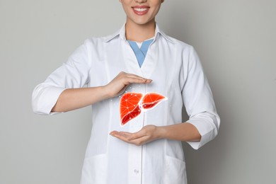 Image of Doctor and illustration of healthy liver on beige background, closeup