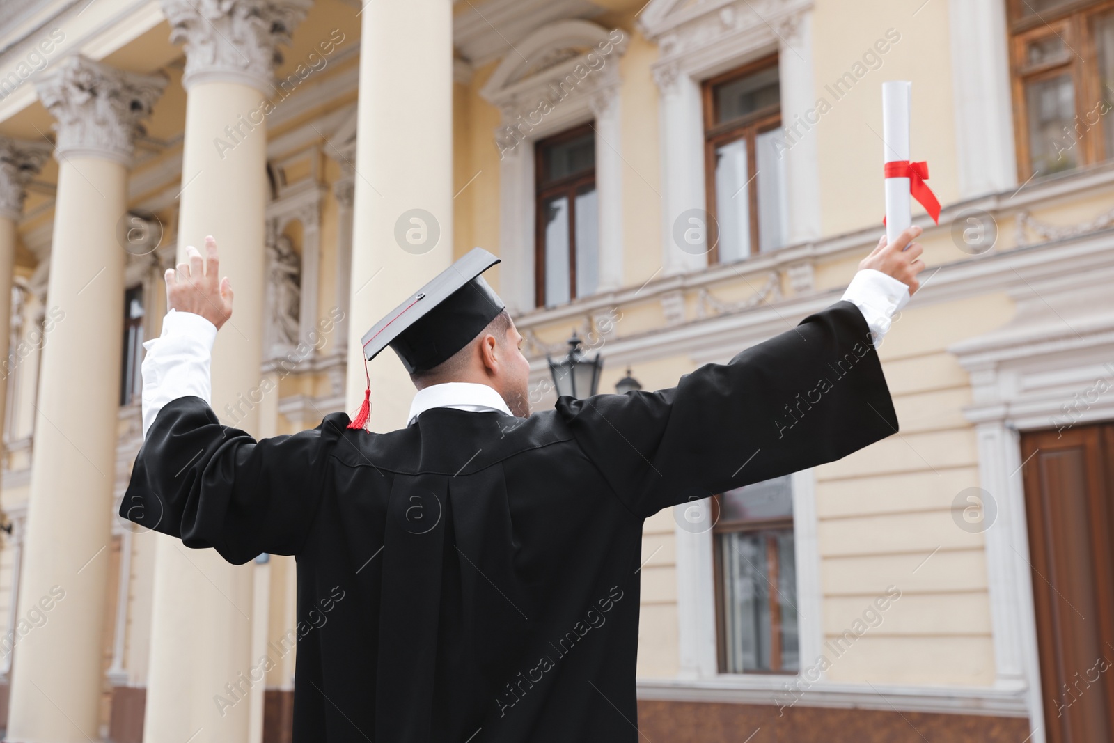 Photo of Student with diploma after graduation ceremony outdoors