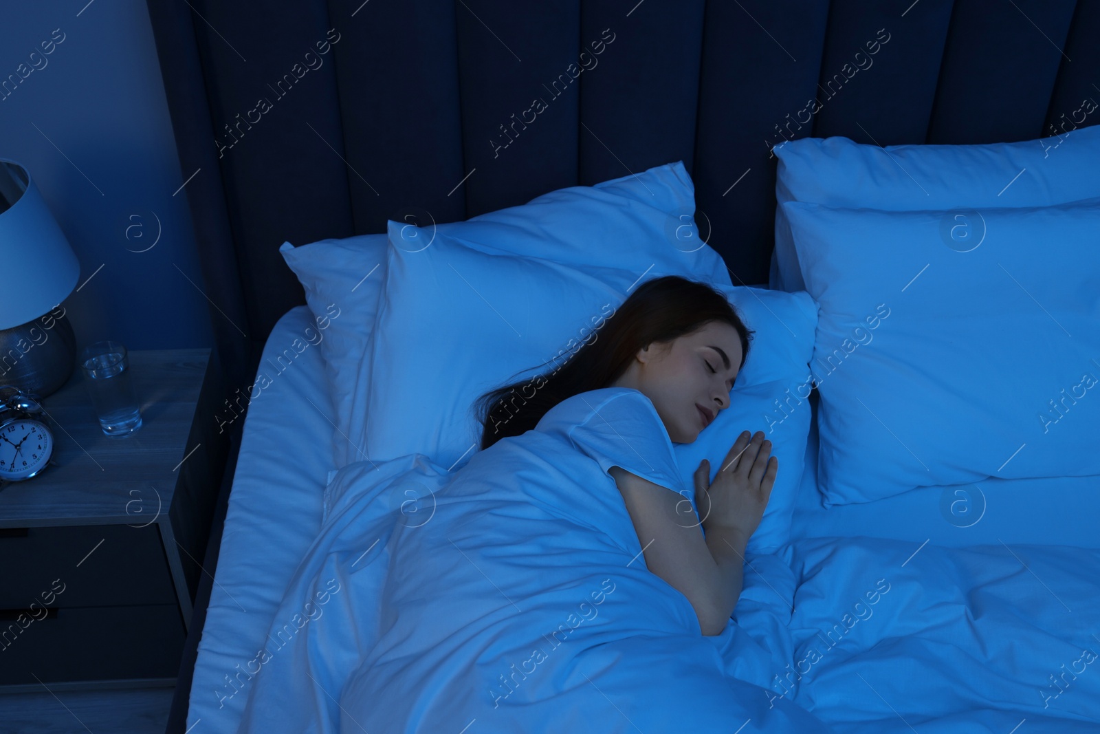 Photo of Beautiful young woman sleeping in bed at night