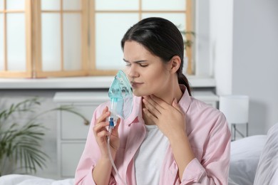 Photo of Sick young woman using nebulizer at home