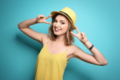 Photo of Beautiful young woman with stylish hat posing on color background