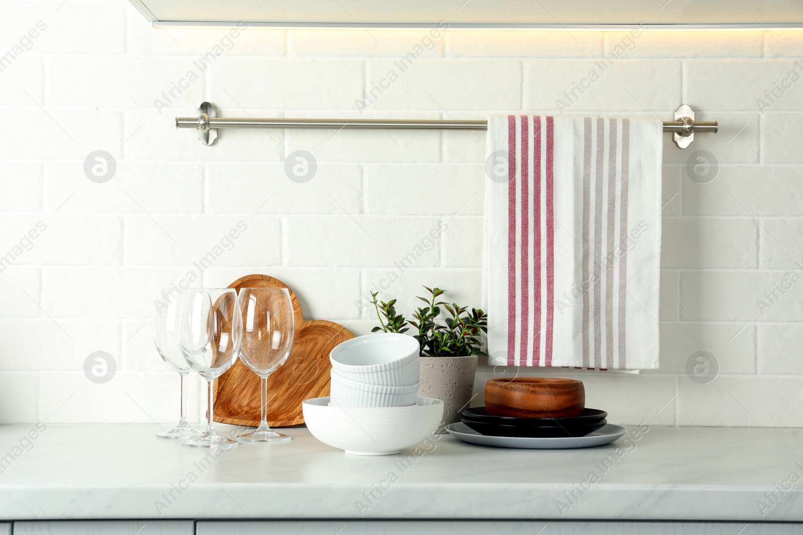Photo of Set of clean tableware on white countertop in kitchen