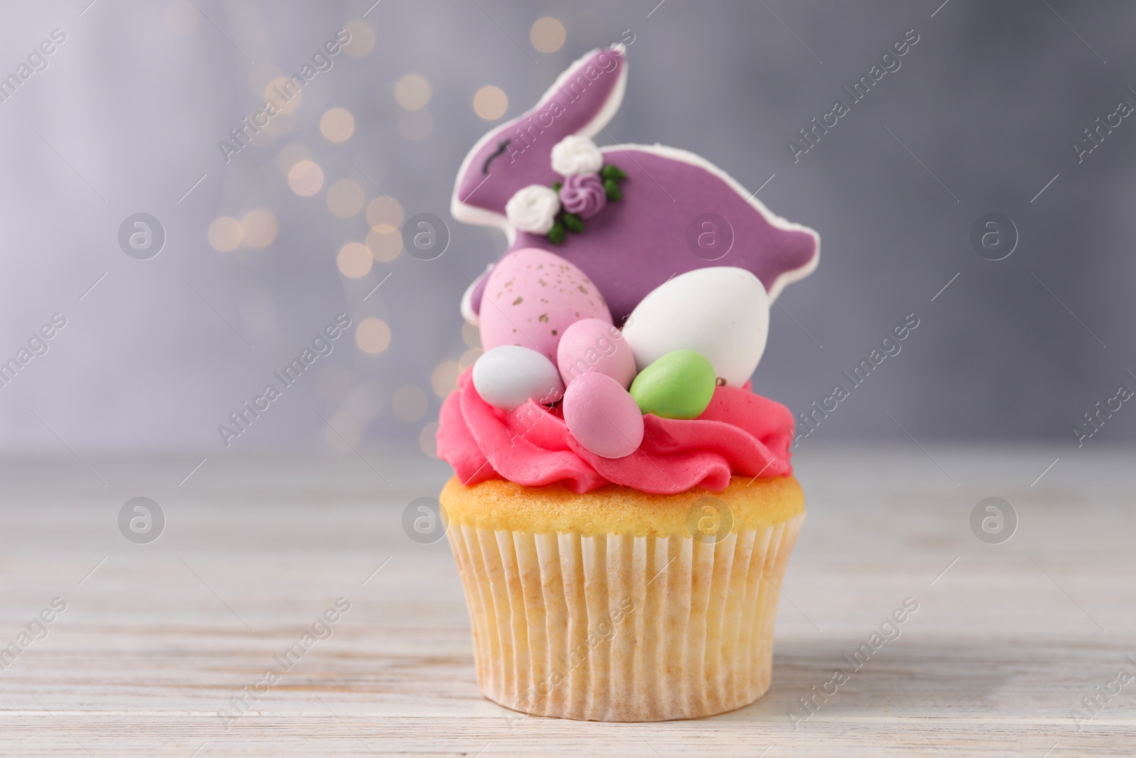 Photo of Tasty cupcake with Easter decor on wooden table