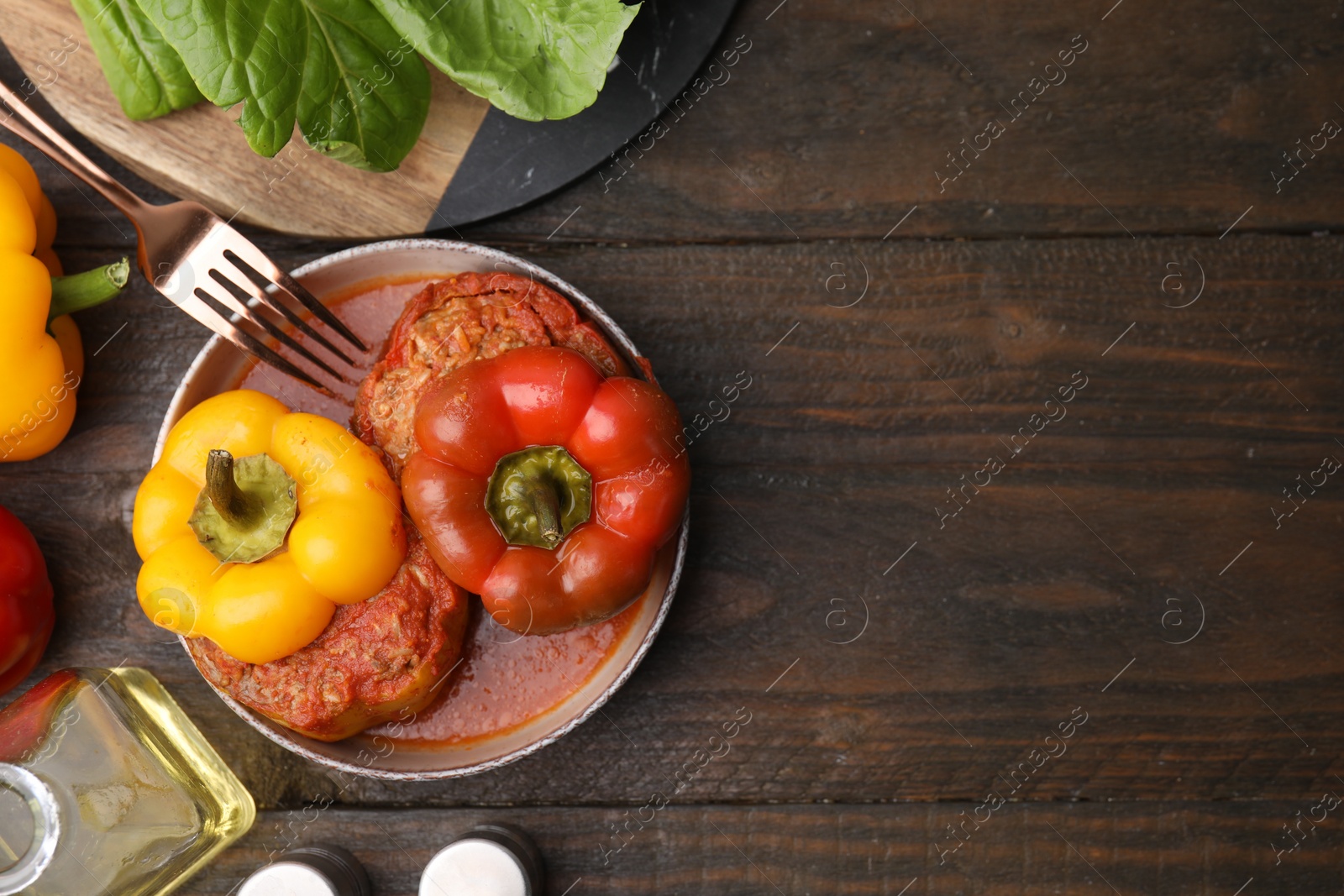 Photo of Delicious stuffed bell peppers served on wooden table, flat lay. Space for text