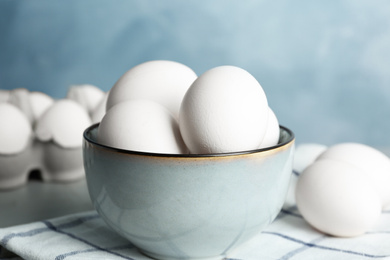 Photo of Chicken eggs in ceramic bowl on table