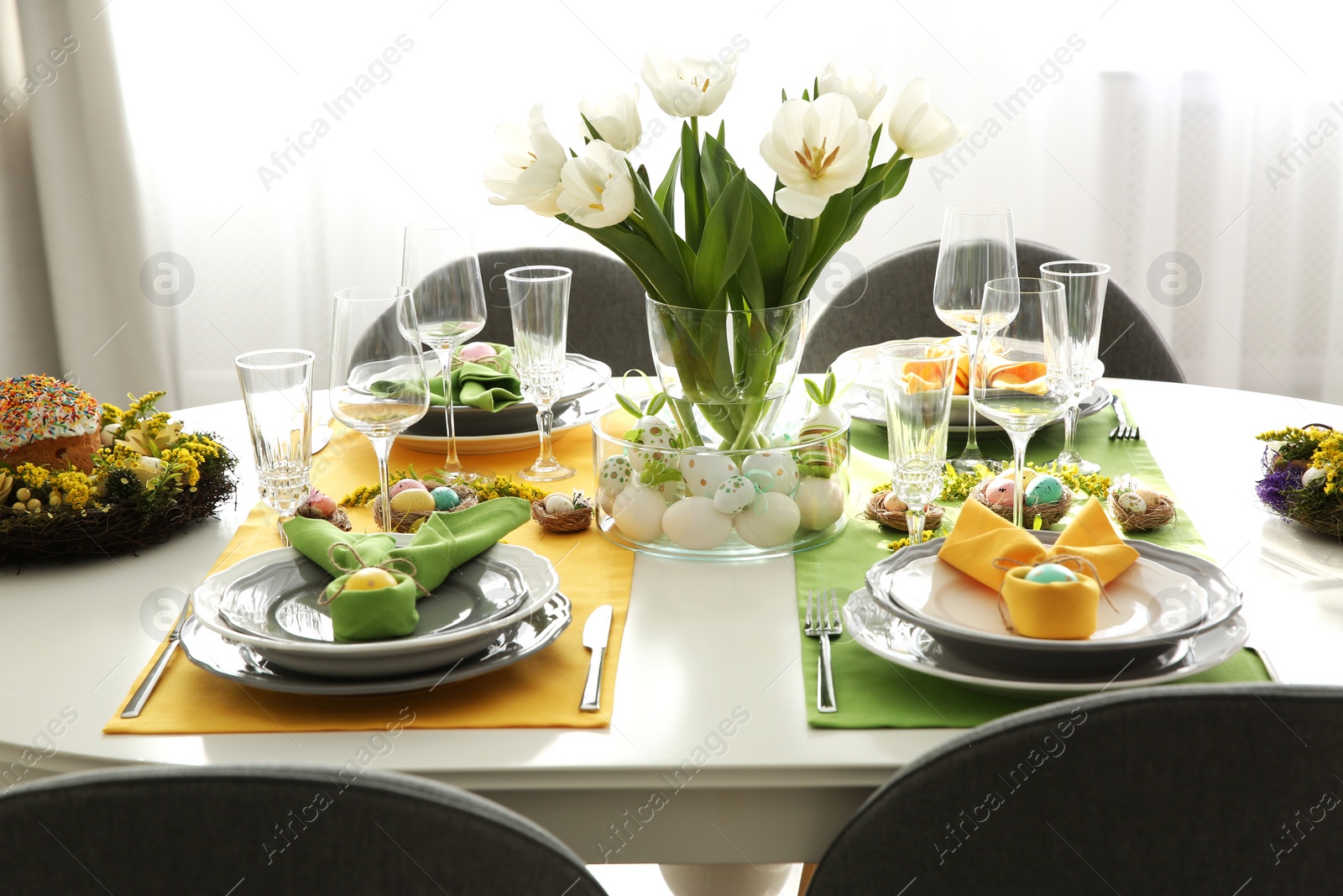 Photo of Festive Easter table setting with beautiful white tulips and eggs indoors