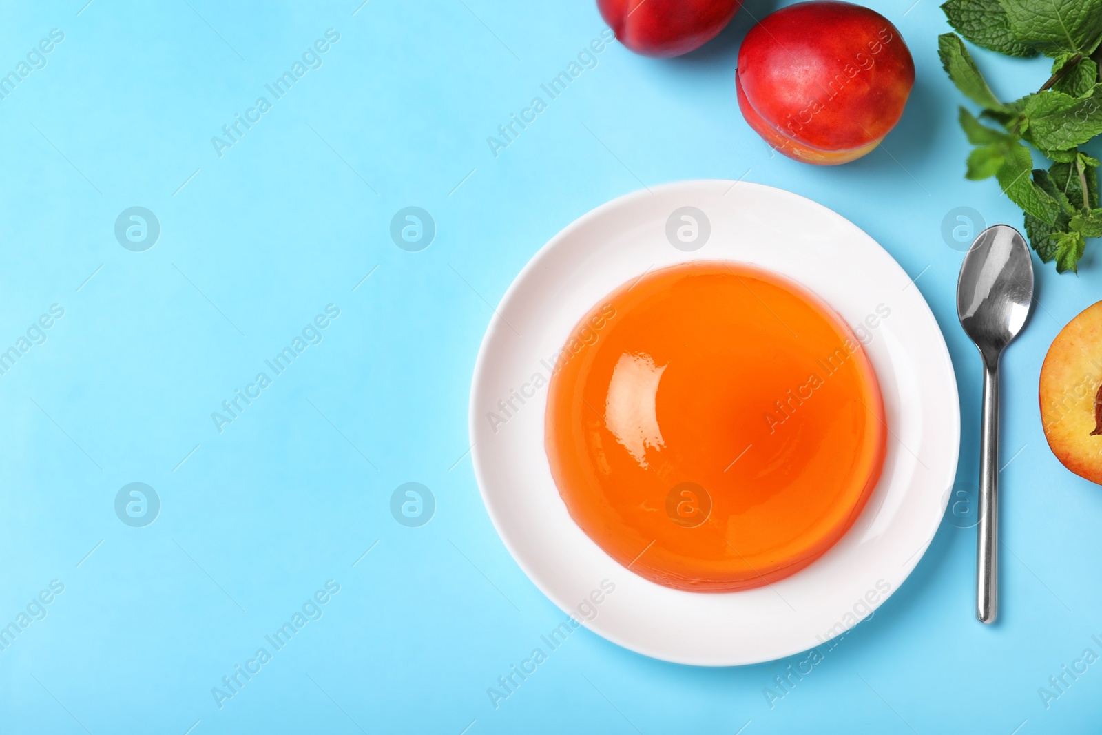 Photo of Delicious fresh orange jelly on blue background, flat lay. Space for text